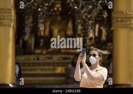 Eine Touristin trägt eine schützende Gesichtsmaske und macht am 02. Februar 2020 ein Foto, als sie die Shwe Dagon Pagode in Yangon, Myanmar besucht. Die Regierung von Myanmar hat am Samstag die Visa für chinesische Touristen bei der Ankunft ausgesetzt. Die Weltgesundheitsorganisation (WHO) hat den Ausbruch des Coronavirus am 30. Januar 2020 zu einem globalen Notfall erklärt. Die Zahl der Todesopfer nach dem Ausbruch des Virus stieg auf über 300 und mehr als 14.000 Fälle wurden bestätigt (Foto: Shwe Paw Mya Tin/NurPhoto) Stockfoto