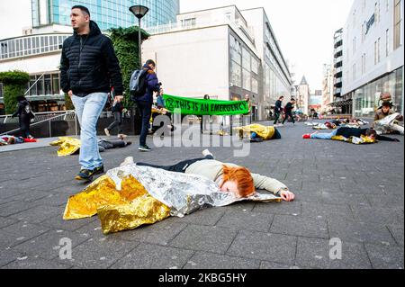 Während der dritten Extinction Rebellion die in Aktion, am 3.. Februar 2020 in Rotterdam, passiert neben einem XR-Aktivisten ein Mann, der einen falschen Toten vorgibt. (Foto von Romy Arroyo Fernandez/NurPhoto) Stockfoto