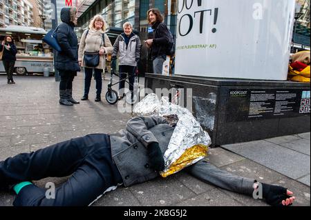 Eine Gruppe von Menschen spricht, während ein XR-Aktivist während des Dritten Extinction Rebellion die in Aktion, am 3.. Februar 2020 in Rotterdam, auf dem Boden liegt und vorgibt, einen falschen Toten zu sterben. (Foto von Romy Arroyo Fernandez/NurPhoto) Stockfoto