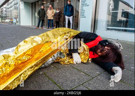 Eine Gruppe von Menschen spricht, während ein XR-Aktivist während des Dritten Extinction Rebellion die in Aktion, am 3.. Februar 2020 in Rotterdam, auf dem Boden liegt und vorgibt, einen falschen Toten zu sterben. (Foto von Romy Arroyo Fernandez/NurPhoto) Stockfoto