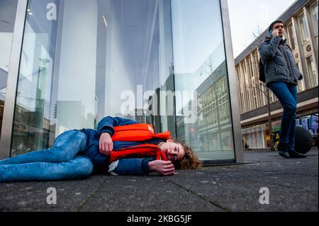 Ein XR-Aktivist täuscht vor, ein falscher Tod zu sein, während ein Mann am 3.. Februar 2020 in Rotterdam beim dritten Extinction Rebellion die in Aktion in Aktion ist, indem er mit seinem Telefon spricht. (Foto von Romy Arroyo Fernandez/NurPhoto) Stockfoto