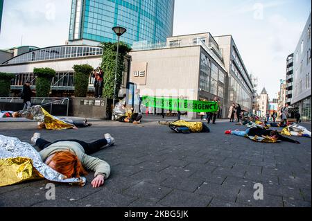 Eine XR-Gruppe von Aktivisten gibt vor, einen falschen Toten zu haben, während ein anderer Aktivist während des Dritten Extinction Rebellion die in Aktion am 3.. Februar 2020 in Rotterdam eine Rede hält. (Foto von Romy Arroyo Fernandez/NurPhoto) Stockfoto