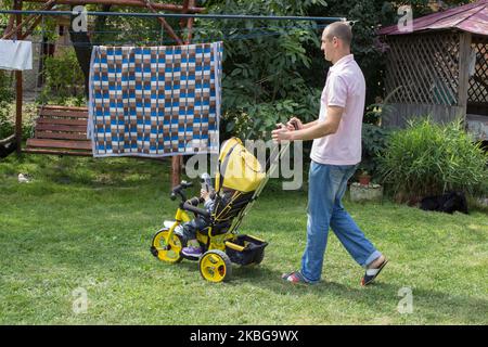 Vater transportierte ein Kind auf einem Dreirad Stockfoto