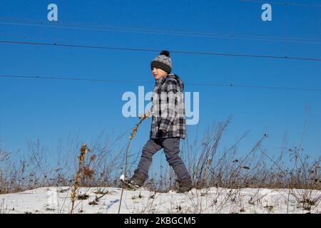 Gehen Sie im Winter im Schnee an einem sonnigen Tag gegen den Himmel blau Stockfoto