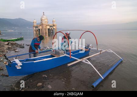 Fischer bereiten ihre Boote und Angelruten vor, um in der Nähe der schwimmenden Moschee, die am 9. Februar 2020 am Kampung Lere Beach, Palu, Central Sulawesi, Indonesien, ins Meer einstürzte, zu gehen. Die Lebenssituation in der Umgebung normalisiert sich allmählich, nachdem sie am 28. September 2018 von einem Tsunami getroffen wurde, bei dem Tausende von Einwohnern ums Leben kamen. Trotzdem verbieten die lokalen Behörden den Anwohnern, sich aufgrund von Katastrophengebieten dort umzusiedeln. (Foto von Basri Marzuki/NurPhoto) Stockfoto