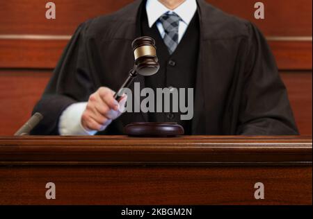Männlicher Richter, der nach dem Urteil im Gerichtssaal den Gavel anschlagen hatte Stockfoto