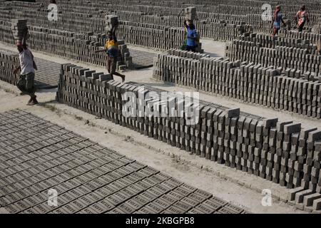 Am Montag, den 20. Februar 2020, tragen Arbeiter auf einem Ziegelfeld in der Nähe des Flusses Buriganga in Dhaka, Bangladesch, rohe Ziegelsteine auf dem Kopf. (Foto von Syed Mahamudur Rahman/NurPhoto) Stockfoto