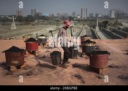 Ein Arbeiter trägt Kohle, um am Montag, den 20. Februar 2020, auf einem Ziegelfeld in der Nähe des Flusses Buriganga in Dhaka, Bangladesch, zu verbrennen. (Foto von Syed Mahamudur Rahman/NurPhoto) Stockfoto