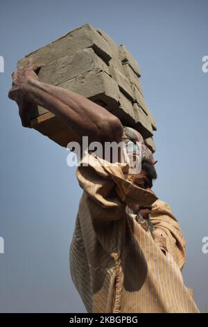 Ein Arbeiter carrie roh am Montag, den 20. Februar 2020, auf einem Ziegelfeld in der Nähe des Flusses Buriganga in Dhaka, Bangladesch, Ziegelsteine auf seinen Kopf. (Foto von Syed Mahamudur Rahman/NurPhoto) Stockfoto