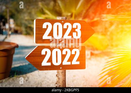 2023 Konzept für das neue Jahr. Wegweiser mit Neujahr 2023 Richtung auf sonnigen tropischen Sommerstrand. Optimismus, Positivität, Ziele. Hochwertige Fotos Stockfoto