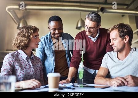 Wir schaffen es durch Teamarbeit. Ein kreatives Team, das eine Brainstorming-Sitzung im Sitzungssaal hat. Stockfoto