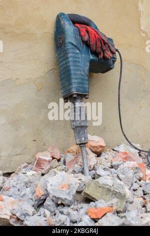 Werkzeug Presslufthammer auf einer Wand aus Steinziegeln stehen Stockfoto