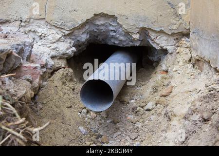 Bau der Abwasserkanalleitung durch die Wand zur Straße Stockfoto