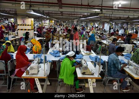 Arbeiter in Bangladesch arbeitet am 13. Februar 2020 in einer Bekleidungsfabrik in Savar, einem Vorort von Dhaka, Bangladesch. Der Bekleidungssektor hat Frauen aus den ländlichen Gebieten, die zuvor keine Möglichkeit hatten, Teil der formellen Belegschaft zu sein, Beschäftigungsmöglichkeiten eröffnet. Dies hat Frauen die Chance gegeben, finanziell unabhängig zu sein und eine Stimme in der Familie zu haben, weil sie jetzt finanziell beitragen. Allerdings sind weibliche Arbeitnehmer mit Problemen konfrontiert. Die meisten Frauen kommen aus Familien mit niedrigem Einkommen. Der niedrige Lohn von Arbeitnehmerinnen und ihre Einhaltung haben es der Branche ermöglicht, mit dem Weltmarkt zu konkurrieren. Th Stockfoto