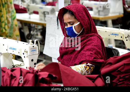 Arbeiter in Bangladesch arbeitet am 13. Februar 2020 in einer Bekleidungsfabrik in Savar, einem Vorort von Dhaka, Bangladesch. Der Bekleidungssektor hat Frauen aus den ländlichen Gebieten, die zuvor keine Möglichkeit hatten, Teil der formellen Belegschaft zu sein, Beschäftigungsmöglichkeiten eröffnet. Dies hat Frauen die Chance gegeben, finanziell unabhängig zu sein und eine Stimme in der Familie zu haben, weil sie jetzt finanziell beitragen. Allerdings sind weibliche Arbeitnehmer mit Problemen konfrontiert. Die meisten Frauen kommen aus Familien mit niedrigem Einkommen. Der niedrige Lohn von Arbeitnehmerinnen und ihre Einhaltung haben es der Branche ermöglicht, mit dem Weltmarkt zu konkurrieren. Th Stockfoto