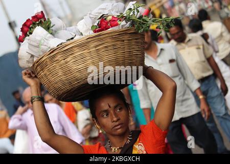 Eine Frau bewegt sich am 13. Februar 2020 auf einem Blumenmarkt in Mumbai, Indien, durch die Menschenmenge und balanciert einen Korb mit roten Rosen. (Foto von Himanshu Bhatt/NurPhoto) Stockfoto