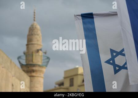 Eine israelische Flagge mit Blick auf ein Minarett im Hintergrund, gesehen auf Jaffas Flohmarkt, Tel Aviv. Am Montag, den 10. Februar 2020, in Tel Aviv, Israel. (Foto von Artur Widak/NurPhoto) Stockfoto