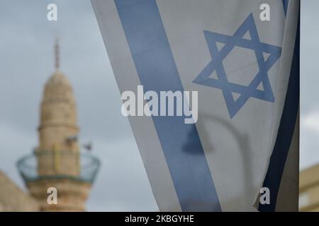 Eine israelische Flagge mit Blick auf ein Minarett im Hintergrund, gesehen auf Jaffas Flohmarkt, Tel Aviv. Am Montag, den 10. Februar 2020, in Tel Aviv, Israel. (Foto von Artur Widak/NurPhoto) Stockfoto