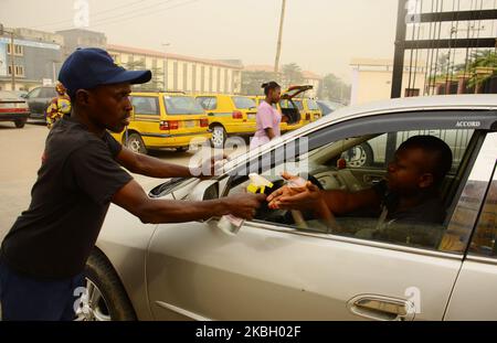 Ein Beamter des nigerischen Sicherheits- und Zivilschutzkorps spieß eine Menschenhand mit Handdesinfektionsmittel vor das Gbagada General Hospital, nachdem in Lagos am 14. Februar 2020 in Nigeria die Zahl der Todesopfer beim Lassa-Fieber 70 erreicht hatte. (Foto von Olukayode Jaiyeola/NurPhoto) Stockfoto