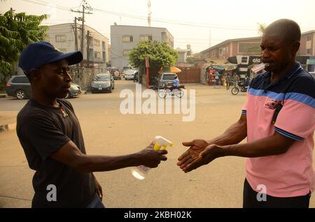 Ein Beamter des nigerischen Sicherheits- und Zivilschutzkorps spieß eine Menschenhand mit Handdesinfektionsmittel vor das Gbagada General Hospital, nachdem in Lagos am 14. Februar 2020 in Nigeria die Zahl der Todesopfer beim Lassa-Fieber 70 erreicht hatte. (Foto von Olukayode Jaiyeola/NurPhoto) Stockfoto