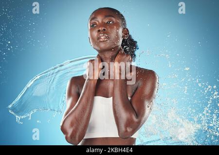 Schönheit, Hautpflege und Spritzer, Porträt einer schwarzen Frau mit blauem Hintergrund im Studio-Shooting. Mode, Gesundheit und frisches sauberes Wasser für Frauen mit Stockfoto