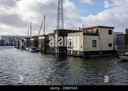 Schwimmende Häuser in Amsterdam, gesehen am 17. Februar 2020. Die Niederlande sind ein von Deichen geschütztes Land, in dem Menschen auf von Menschen gemachten Hügeln leben, die sie über den Meeresspiegel erheben, und im Wasser auf schwimmenden Häusern. Hausboote oder schwimmende Hotels können entlang der Kanäle in Amsterdam und anderen Städten gesehen werden. Schwimmende Häuser wurden als eine praktikable, umweltfreundliche und nachhaltige Lösung für die Wohnbedürfnisse des modernen Hollands vorgeschlagen. Ein Beispiel für schwimmende Häuser in Amsterdam ist auf Steigereiland, der ersten Insel, die Teil des menschgemachten IJburg-Archipels im östlichen Teil der Stadt ist. Diese Insel wa Stockfoto