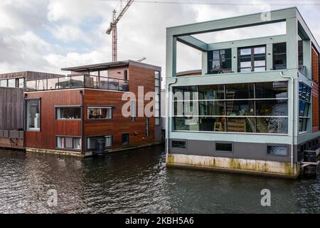 Schwimmende Häuser in Amsterdam, gesehen am 17. Februar 2020. Die Niederlande sind ein von Deichen geschütztes Land, in dem Menschen auf von Menschen gemachten Hügeln leben, die sie über den Meeresspiegel erheben, und im Wasser auf schwimmenden Häusern. Hausboote oder schwimmende Hotels können entlang der Kanäle in Amsterdam und anderen Städten gesehen werden. Schwimmende Häuser wurden als eine praktikable, umweltfreundliche und nachhaltige Lösung für die Wohnbedürfnisse des modernen Hollands vorgeschlagen. Ein Beispiel für schwimmende Häuser in Amsterdam ist auf Steigereiland, der ersten Insel, die Teil des menschgemachten IJburg-Archipels im östlichen Teil der Stadt ist. Diese Insel wa Stockfoto