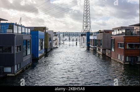 Schwimmende Häuser in Amsterdam, gesehen am 17. Februar 2020. Die Niederlande sind ein von Deichen geschütztes Land, in dem Menschen auf von Menschen gemachten Hügeln leben, die sie über den Meeresspiegel erheben, und im Wasser auf schwimmenden Häusern. Hausboote oder schwimmende Hotels können entlang der Kanäle in Amsterdam und anderen Städten gesehen werden. Schwimmende Häuser wurden als eine praktikable, umweltfreundliche und nachhaltige Lösung für die Wohnbedürfnisse des modernen Hollands vorgeschlagen. Ein Beispiel für schwimmende Häuser in Amsterdam ist auf Steigereiland, der ersten Insel, die Teil des menschgemachten IJburg-Archipels im östlichen Teil der Stadt ist. Diese Insel wa Stockfoto