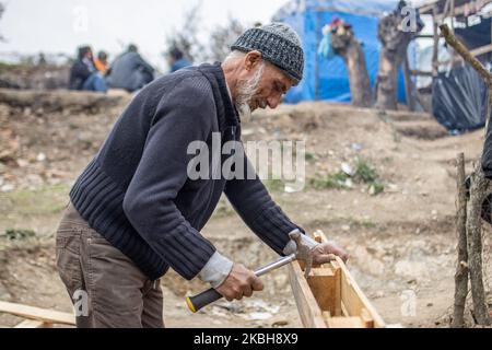 Asylbewerber aus Afghanistan bauen im provisorischen Lager außerhalb des offiziellen Flüchtlingslagers Moria ein neues Zelt. Die neuen Zelte werden in einem Olivenhain gebaut, nachdem Olivenbäume mit flachen Paletten und Plastik herum verbrannt und geschnitten wurden, da das offizielle Lager voll ist und es keinen Platz für die etwa 24,000 Menschen gibt, die dort leben, und die Neuankömmlinge aus der Türkei über Schlauchboote. (Foto von Nicolas Economou/NurPhoto) Stockfoto