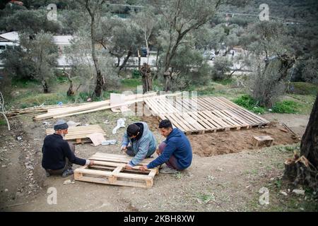 Asylbewerber aus Afghanistan bauen im provisorischen Lager außerhalb des offiziellen Flüchtlingslagers Moria ein neues Zelt. Die neuen Zelte werden in einem Olivenhain gebaut, nachdem Olivenbäume mit flachen Paletten und Plastik herum verbrannt und geschnitten wurden, da das offizielle Lager voll ist und es keinen Platz für die etwa 24,000 Menschen gibt, die dort leben, und die Neuankömmlinge aus der Türkei über Schlauchboote. (Foto von Nicolas Economou/NurPhoto) Stockfoto