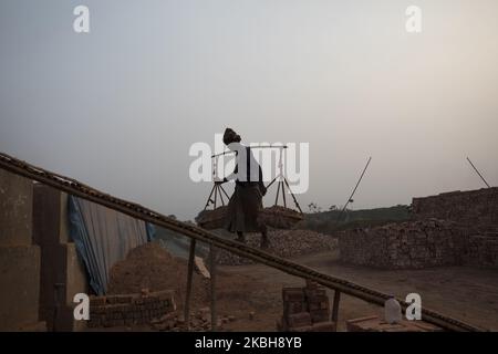 Am 19. Februar 2020 arbeiten Arbeiter in Brickfield in Savar. Die Welt durchläuft eine schnelle Urbanisierung, und Bangladesch bildet dabei keine Ausnahme. Eine solche schnelle Urbanisierung erzeugt eine massive Nachfrage nach Ziegeln, da sie einer der wichtigsten Bestandteile für den Bau einer Betonstruktur ist. Um diesem wachsenden Bedarf gerecht zu werden, hat die Zahl der Felder für die Ziegelherstellung in Bangladesch mit alarmierender Geschwindigkeit zugenommen. Die meisten von ihnen fanden in landwirtschaftlichen Gebieten statt, was zu einer Verringerung der landwirtschaftlichen Produktion führt. Wir wissen, dass die Verbrennung von Kohle einen enormen Ausstoß von Kohlenstoff-Di-Oxid (CO2)-Gas verursacht, das in erster Linie als Respons dient Stockfoto