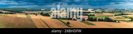 Ein wunderschönes Panorama auf den Westen von Roztocze. Hügelige Hügel, Felder und Wälder. Ein Bauernhof zwischen den Feldern. Roztocze ist als Polens Toskana bekannt. Hoszn Stockfoto