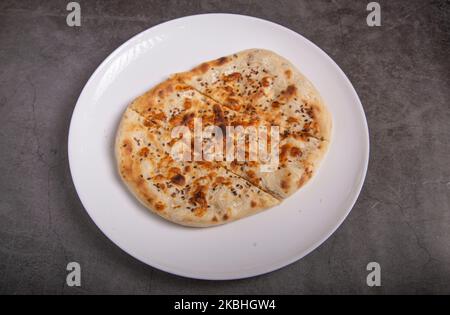 Koriander Naan - Indisches Fladenbrot mit frischen Korianderblättern bestreut und in Tandoor gekocht Stockfoto