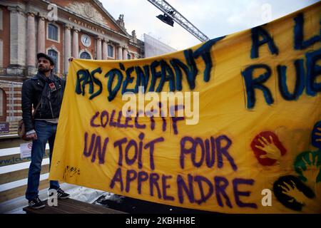 Ein Protestler hält ein Banner vor dem Rathaus von Toulouse, dem Capitole. Auf dem Transparent steht: „Kein Kind auf der Straße, kollektives „Ein Dach zum Lernen“. Die NGO DAL (Droit au Logement dh Right to Housing) organisierte eine Aktion auf der Eislaufbahn auf dem Hauptplatz von Toulouse, dem Capitole, installiert, um an die Präfektur Toulouse, die Anforderung von unbesetzten Gebäuden für die Unterbringung von Obdachlosen und Familien zu fordern. Toulouse. Frankreich. Februar 22. 2020. (Foto von Alain Pitton/NurPhoto) Stockfoto