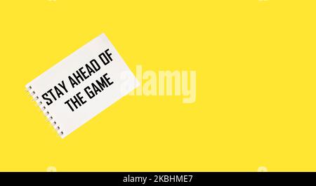 Weiße Karte mit dem Text vor dem Spiel bleiben liegt auf einem gelben Hintergrund Stockfoto