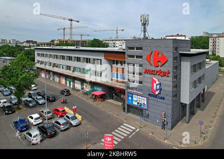 Luftaufnahme des C4 Coworking Space und des Carrefour Market Building in Warschau an einem sonnigen Tag, der städtische Bauten und kommerzielle Aktivitäten erfasst Stockfoto