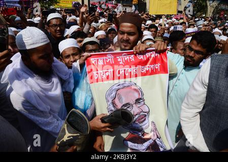 Während einer Protestkundgebung gegen die kommunale Gewalt in Neu-Delhi, Indien, von der Baitul-Mukarram-Nationalmoschee nach dem Freitagsgebet in Dhaka, Bangladesch, schlugen Mitglieder der islamischen Partei aus Bangladesch am 28. Februar 2020 ein Plakat des indischen Premierministers Narendra Modi ein. Bei den Kämpfen zwischen Anhängern und Gegnern des umstrittenen Citizenship Amendment Act (CAA) in Neu Delhi sind mindestens 24 Menschen getötet worden. Das Gesetz, das am 10. Dezember 2019 verabschiedet wurde, gewährt Flüchtlingen aus Hindu-, Jain-, Buddhisten-, Sikh-, Parsi- oder christlichen Gemeinden fleei einen Weg zur indischen Staatsbürgerschaft Stockfoto