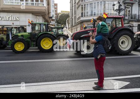 Ein Vater mit seinem Sohn betrachtet den Protest der Bauern, die mit ihren Traktoren die Straßen der Stadt Santander durchschneiden, weil sie am 28. Februar 2020 für ihre Produkte zu einem niedrigen Preis bezahlt werden. (Foto von Joaquin Gomez Sastre/NurPhoto) Stockfoto