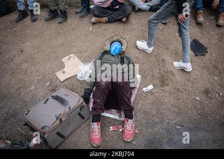 Am 29. Februar 2020 kamen Tausende von Flüchtlingen und Migranten am Grenzübergang Pazarkule zwischen Griechenland und der Türkei an und wurden trotz früherer Behauptungen des türkischen Präs Recep Tayyip Erdogan, dass er die Grenztore für Migranten aus Afghanistan, dem Iran, Pakistan und Syrien, nach einem Zusammenstoß mit syrischen Regimeeinheiten, bei dem mindestens 36 türkische Soldaten in der Provinz Idlib ums Leben kamen. Oben schläft ein junger Mann auf dem Boden nahe der griechischen Grenze, während er seinen Koffer hält. (Foto von Diego Cupolo/NurPhoto) Stockfoto