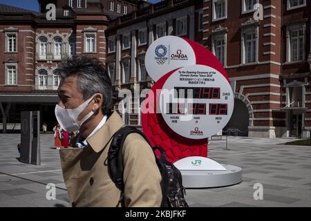 Nach einem Ausbruch des Coronavirus gehen Männer, die Schutzmasken tragen, an den Countdown-Uhren zur Eröffnungszeremonie der Olympischen Spiele 2020 in Tokio, Japan, am 6. März 2020 vorbei. (Foto von Alessandro Di Ciommo/NurPhoto) Stockfoto