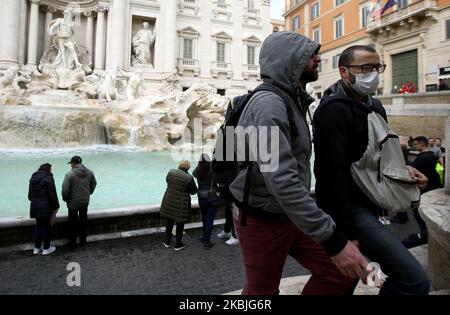 Nachdem die italienische Regierung eine Liste mit neuen Richtlinien herausgegeben hat, die helfen sollen, die Ausbreitung des Coronavirus zu stoppen, hat der zentrale Bereich der Hauptstadt, der normalerweise von Touristen überfüllt ist, einen Rückgang der Präsenzen auf den Straßen unterzeichnet. Auf dem Foto tragen Touristen Gesichtsmasken rund um den Trevi-Brunnen von Rom, Italien, am 6. März 2020 (Foto: Matteo Ciambelli/NurPhoto) Stockfoto