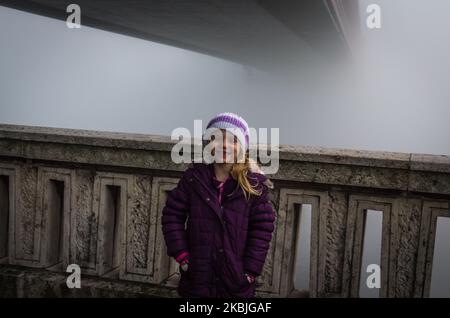 Lange Brücke über Wasser im Nebel und Kind Stockfoto