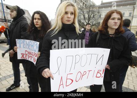 Eine Frau hält ein Plakat mit der Aufschrift „Ich bin gegen Abtreibung“ während eines Protestes ukrainischer rechtsextremen Aktivisten gegen den feministischen Marsch am Internationalen Frauentag im Zentrum von Kiew, Ukraine, am 8. März 2020. Feministinnen, LGBT-Vertreter und Menschenrechtsaktivisten marschierten in der Innenstadt von Kiew zum Internationalen Frauentag, um gegen Sexismus und Gewalt gegen Frauen zu protestieren und die ukrainischen Behörden zur Ratifizierung der Istanbul-Konvention aufzufordern. (Foto von STR/NurPhoto) Stockfoto