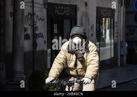 Ein Mann, der eine Gesichtsmask trägt, um die Ausbreitung eines Covid-19-Virus zu stoppen, fährt am 13. März 2020 in Palermo, Italien, ein Fahrrad. (Foto von Francesco Militello Mirto/NurPhoto) Stockfoto