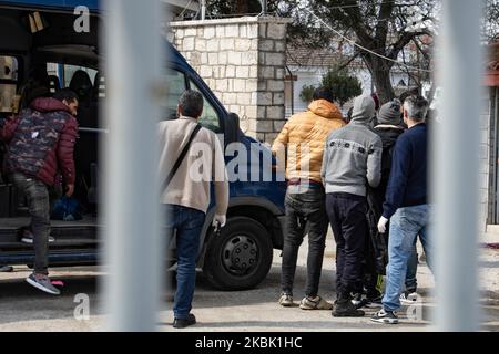 Griechische Polizisten und Grenzpolizisten entladen in Handschellen gefesselte Asylbewerber aus dem Van und begleiten sie zur Neo Chimonio Polizeistation. Die Gruppe von 13 männlichen Migranten und Flüchtlingen, die meisten von ihnen aus Afghanistan, überquerte illegal von der Türkei nach Griechenland, in der Nähe des Grenzübergangs von Kastanies, Evros und wurde am 11. März 2020 festgenommen (Foto: Nicolas Economou/NurPhoto) Stockfoto