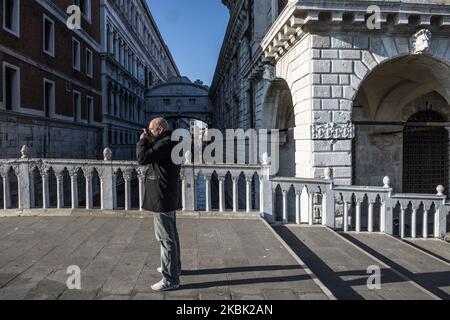 Ein Mann, der am 15. März 2020 während des Coronavirus-Notfalls ein Foto eines leeren Markusplatzes von der Visierbrücke in Venedig, Italien, macht. Die meisten Straßen überall in der Stadt sind leer und nur sehr wenige Menschen auf den Straßen, die ausgehen, um im Supermarkt Lebensmittel zu kaufen oder ihre Hunde zu Fuß zu gehen. (Foto von Giacomo Cosua/NurPhoto) Stockfoto