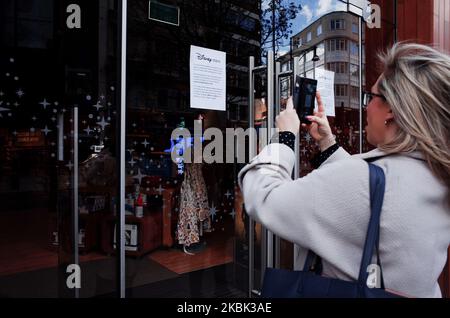 Eine Frau macht ein Foto von einer Benachrichtigung, die die Kunden über die vorübergehende Schließung des Disney-Stores in der Oxford Street in London, England, am 16. März 2020 über Coronavirus-Bedenken informiert. Im ganzen Land, wie auch in anderen Teilen der Welt, eskalieren die Befürchtungen wegen des Covid-19-Coronavirus weiter, da die Zahl der Fälle und Todesfälle weiter steigt. Der britische Premierminister Boris Johnson steht unterdessen weiterhin unter Druck wegen der so genannten Herdenimmunitätsstrategie der Regierung, die den von Ländern wie Italien und Spanien verfolgten Ansatz der Schließung und Sperrung unterstellt. (Foto von David Cliff/NurPhoto) Stockfoto