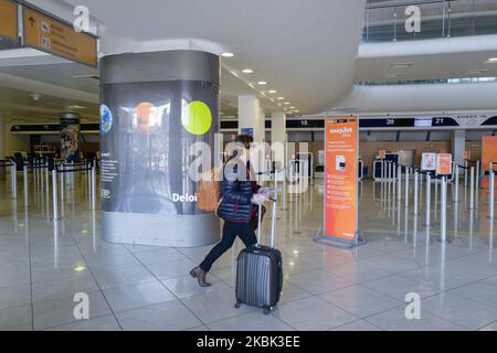 Eine Frau trägt Gesichtsmaske als Vorsichtsmaßnahme gegen Coronavirus (COVID-19) Spaziergänge in einem leeren Check-in-Schalter werden am 16. März 2020 an einem Terminal des Flughafens von Neapel, Italien, gesehen, wo der Flugverkehr aufgrund der Ausbreitung des neuartigen Coronavirus langsamer wurde. (Foto von Paolo Manzo/NurPhoto) Stockfoto