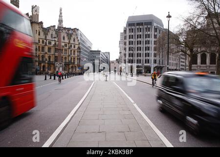 Ein Bus und ein Taxi fahren am 20. März auf einem fast menschenleeren Broad Sanctuary in der Nähe des Parliament Square in London, England, 2020. Im Vereinigten Königreich wurde heute bekannt, dass die Wissenschaftliche Beratungsgruppe für Notfälle (SAGE) der Regierung empfohlen hat, eine Form von „sozialen Distanzierungsmaßnahmen“ für die meiste Zeit eines Jahres zu ergreifen, wobei in diesem Zeitraum immer weniger und strengere Beschränkungen gelten, Um die Ausbreitung des Covid-19-Coronavirus zu bewältigen und eine Überwälzung der Krankenhäuser zu verhindern. Inzwischen schließen die Schulen im ganzen Land bis auf weiteres, mit Ausnahme Stockfoto