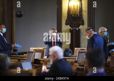 Mitglieder des Stadtrats von Krakau tragen wegen der Ausbreitung des Coronavirus Schutzmasken und Handschuhe, während sie am 20.. März 2020 im Rathaus in Krakau, Polen, an einer Sondersitzung teilnehmen. Seit März 13 befindet sich das Land in einer „epidemischen Bedrohung“. Dieser Status wurde nun zu einem „Seuchenzustand“ aufgewertet, der den Behörden die Möglichkeit geben wird, beispielsweise medizinisches Personal und andere Regierungsmitarbeiter zu verlegen und Transportbeschränkungen einzuführen. (Foto von Beata Zawrzel/NurPhoto) Stockfoto